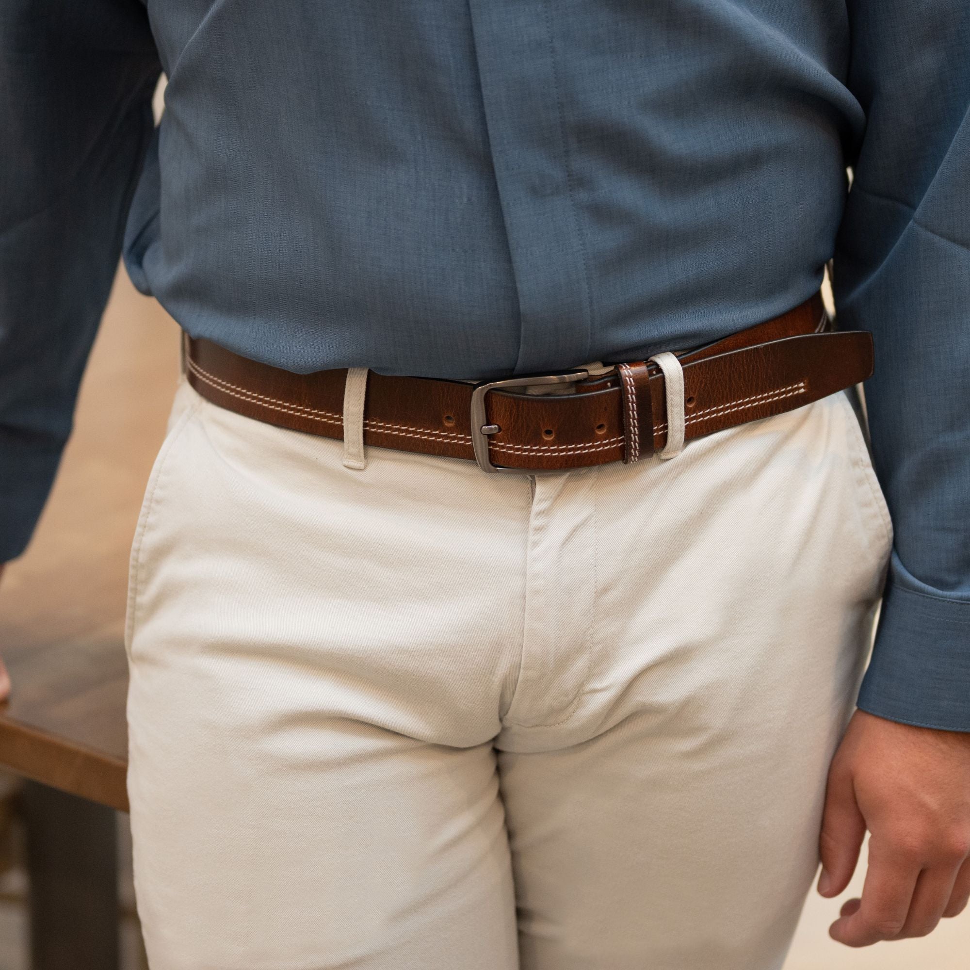 Millennial Brown Stitched Leather Belt on a male model in khakis and a blue button up shirt