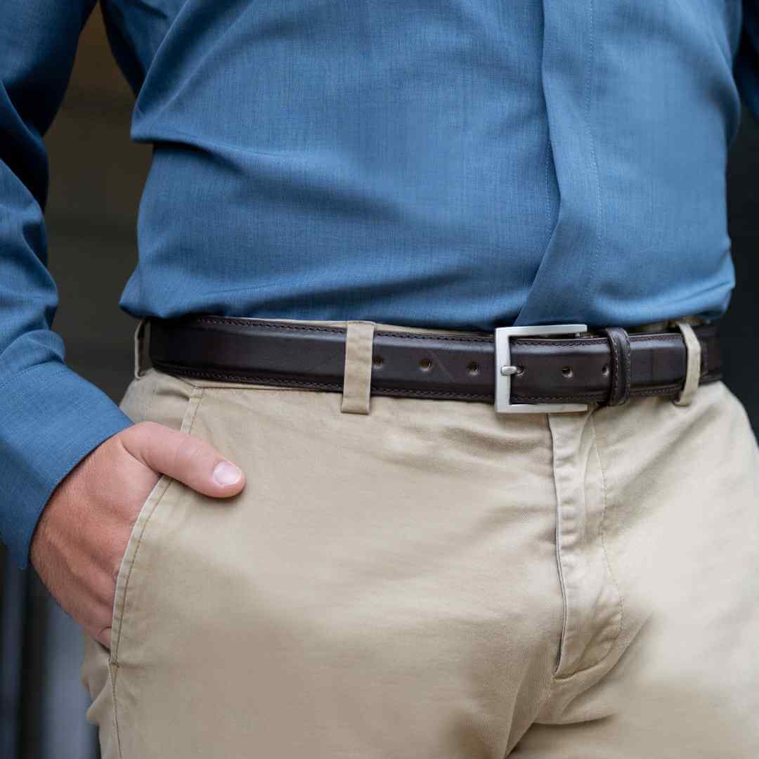 Brown leather dress belt with raised center and side stitching. Silver, rectangular buckle