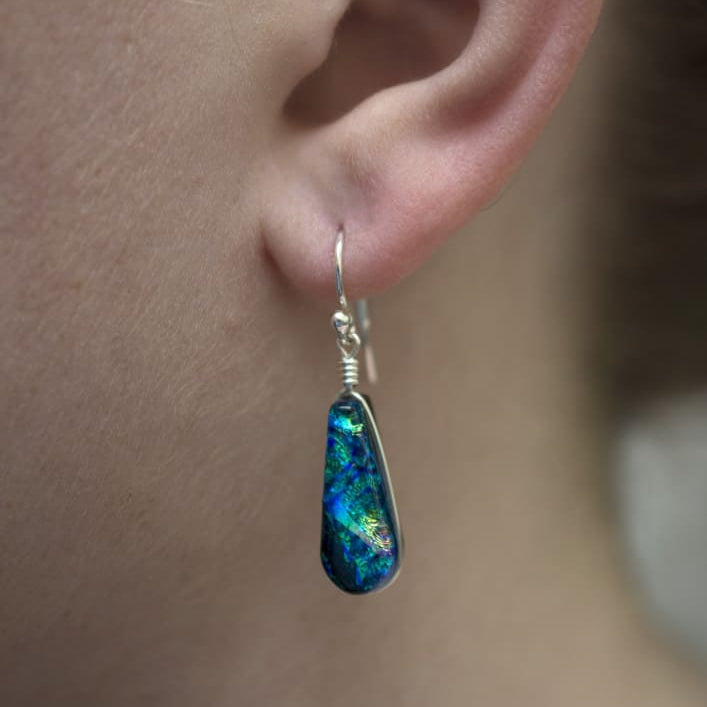 Cedar Rock Falls Earrings on a model. Dichroic glass dangles, approximately 1" (25 mm) long.