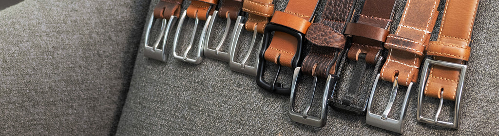 Image of 9 leather belts over a chair. All have brown leather straps and nickel free buckles. Buckles made from zinc, carbon fiber and titanium