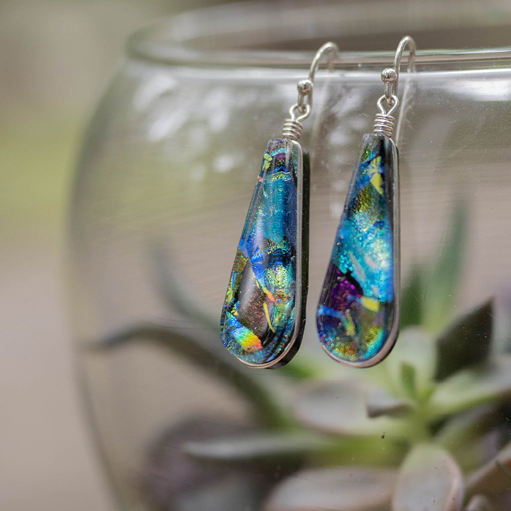 Image of 1 pair of Cedar Rock dichroic glass earrings. Multicolor glass in teardrop shape dangle earring. Nickel Free silver earring wires.