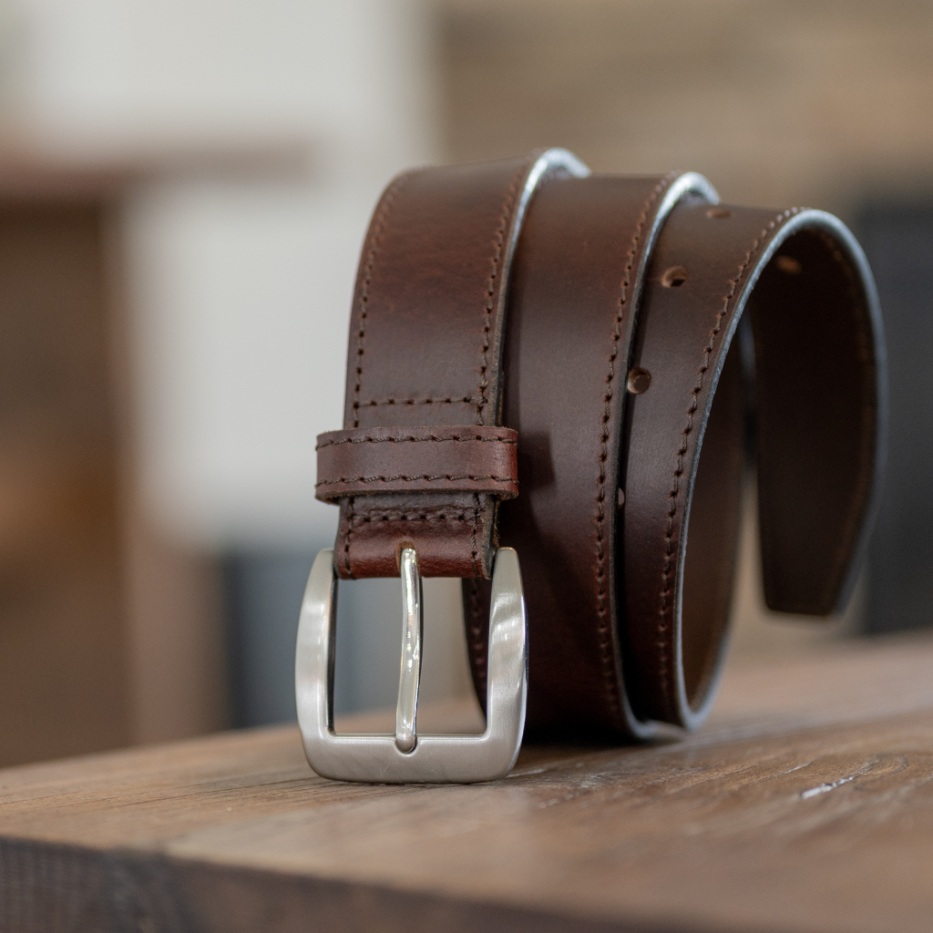 Casual brown leather belt sitting on a wood table
