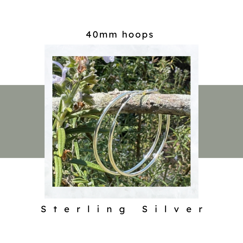 Sterling Silver Hoop Earrings 40 mm hanging on rosemary branch. Hypoallergenic. Endless loop closure