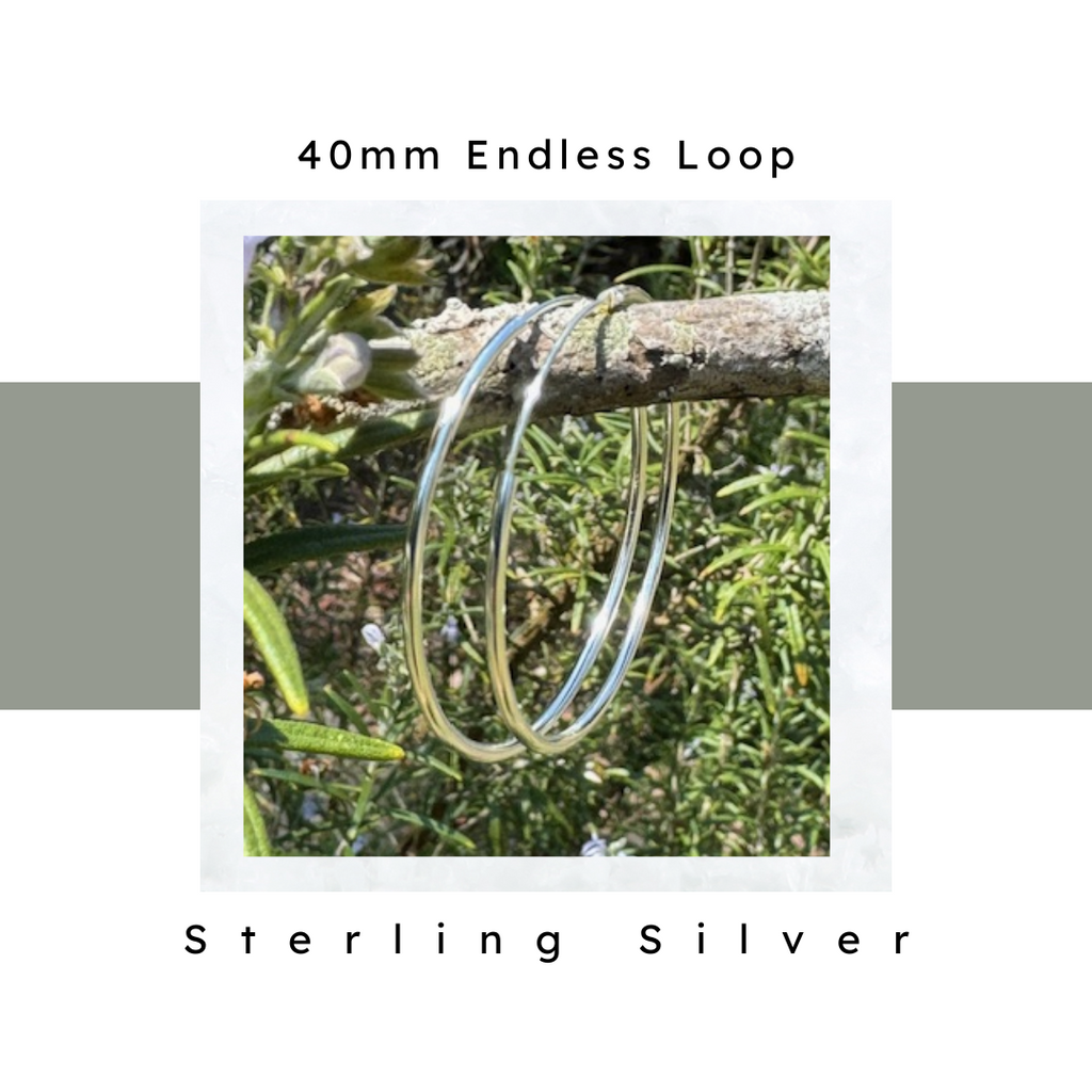 Sterling Silver Hoop Earrings 40 mm hanging on rosemary branch. Hypoallergenic & nickel free