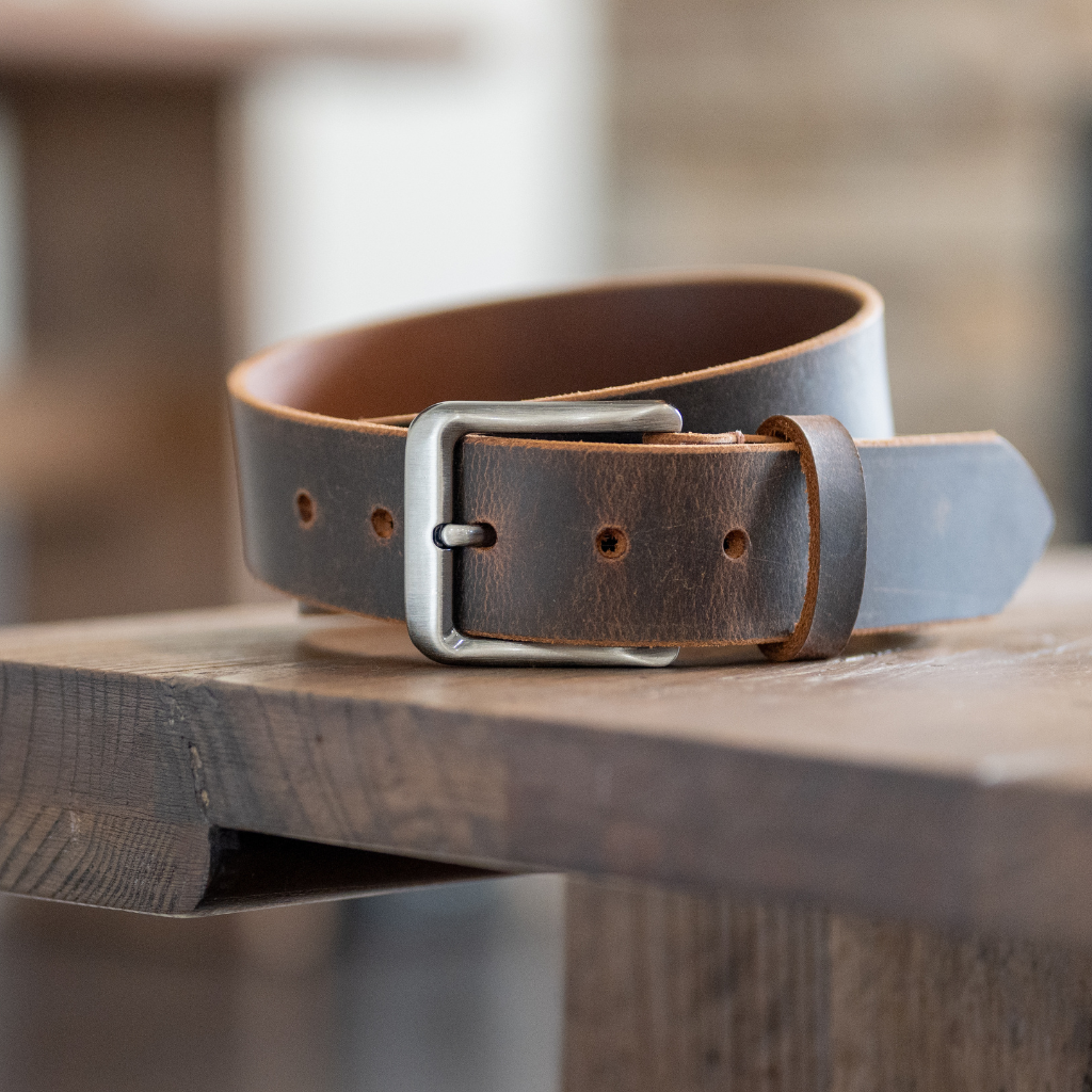 Image of Roan Mountain Distressed Leather Belt sitting on wood table