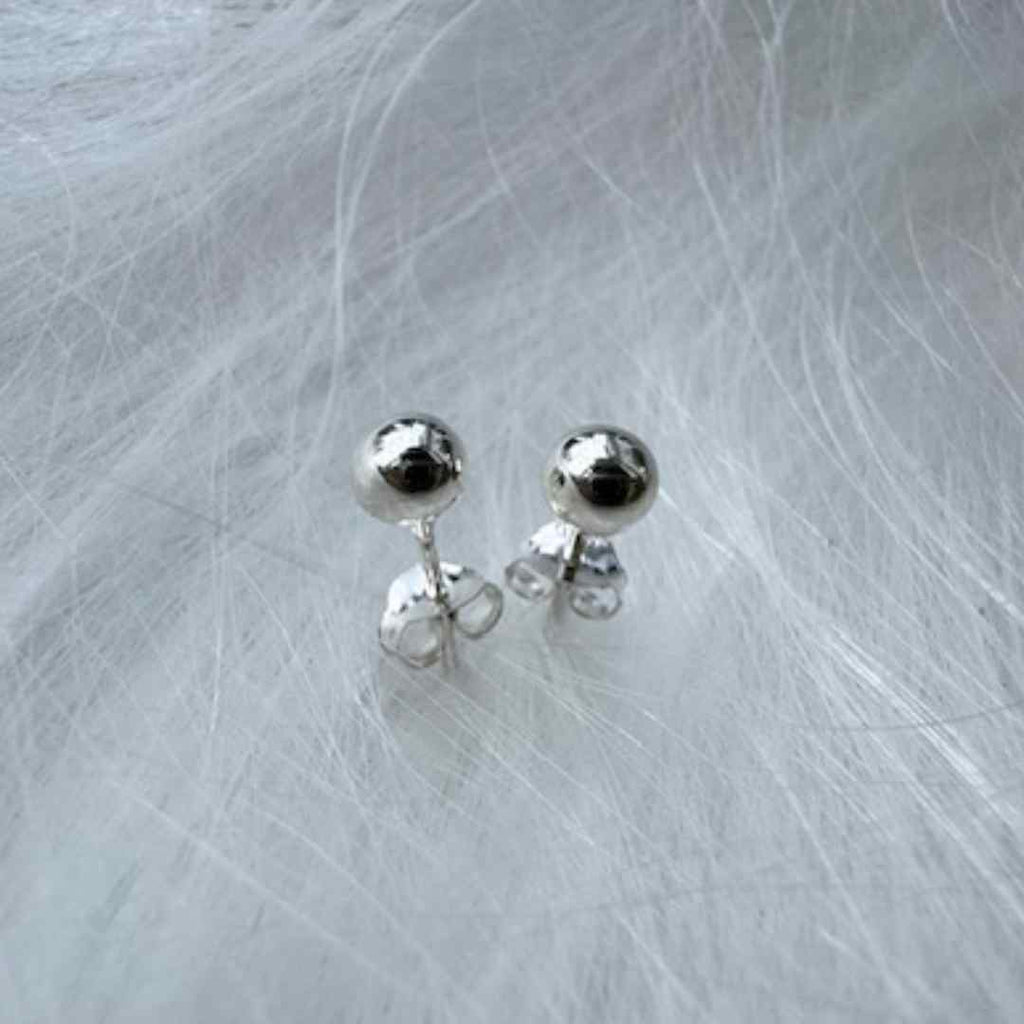 Sterling silver ball earrings on white background. 5-6 mm balls. butterfly backing. nickel free.