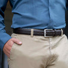 Brown leather dress belt with raised center and side stitching. Silver, rectangular buckle