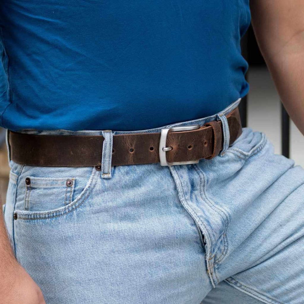Silver, curved low profile buckle for sleek design with 1.5 inch distressed brown leather strap