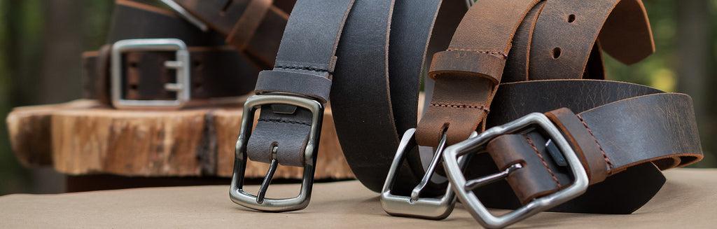 Image of leather belts of various black and brown colors.  All with silver, nickel free buckles. All full grain leather belts