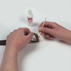 Model testing a belt buckle for nickel. The pink color on the swab indicates nickel is present.