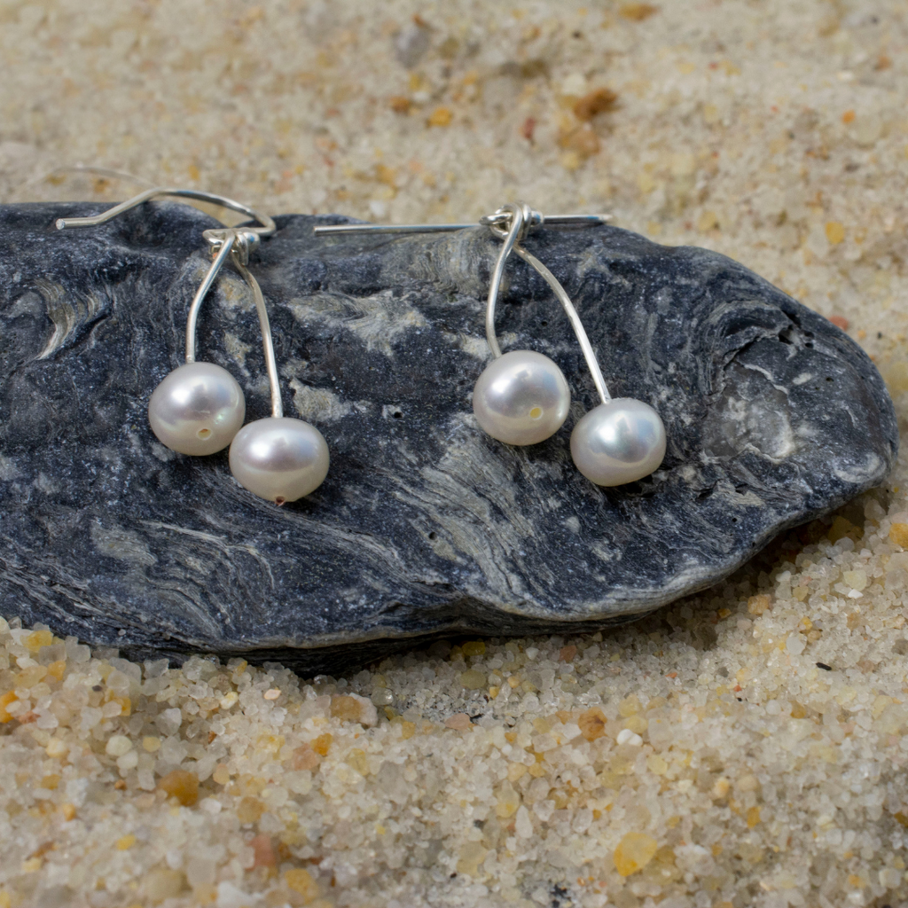 A pair of freshwater pearls laying on oyster shell.  Each earring has 2 separate pearls. Nickel Free