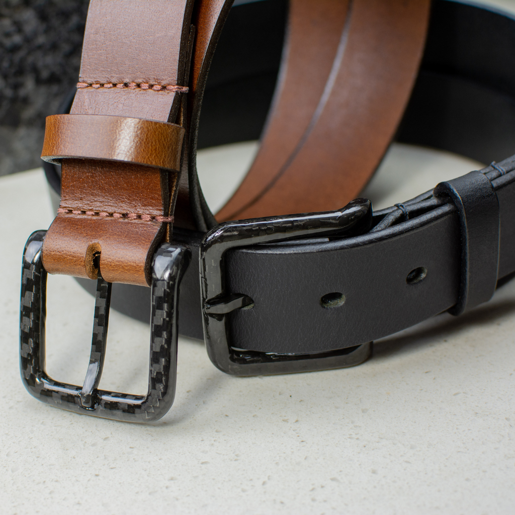 Image of 2 belts. 1 black and 1 brown leather 1⅜ inches (35 mm) wide with carbon fiber buckle.