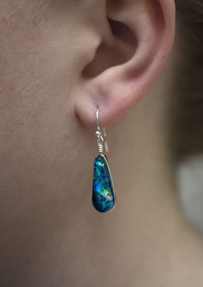 Cedar Rock Falls Earrings on a model. Dichroic glass dangles, approximately 1" (25 mm) long.