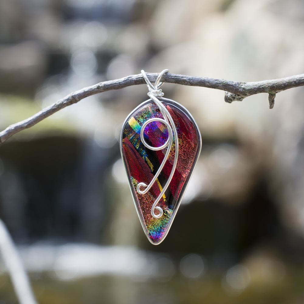 Ivy Pendant - Rainbow Red. Outdoor setting. Inverse teardrop shaped dichroic glass pendant.