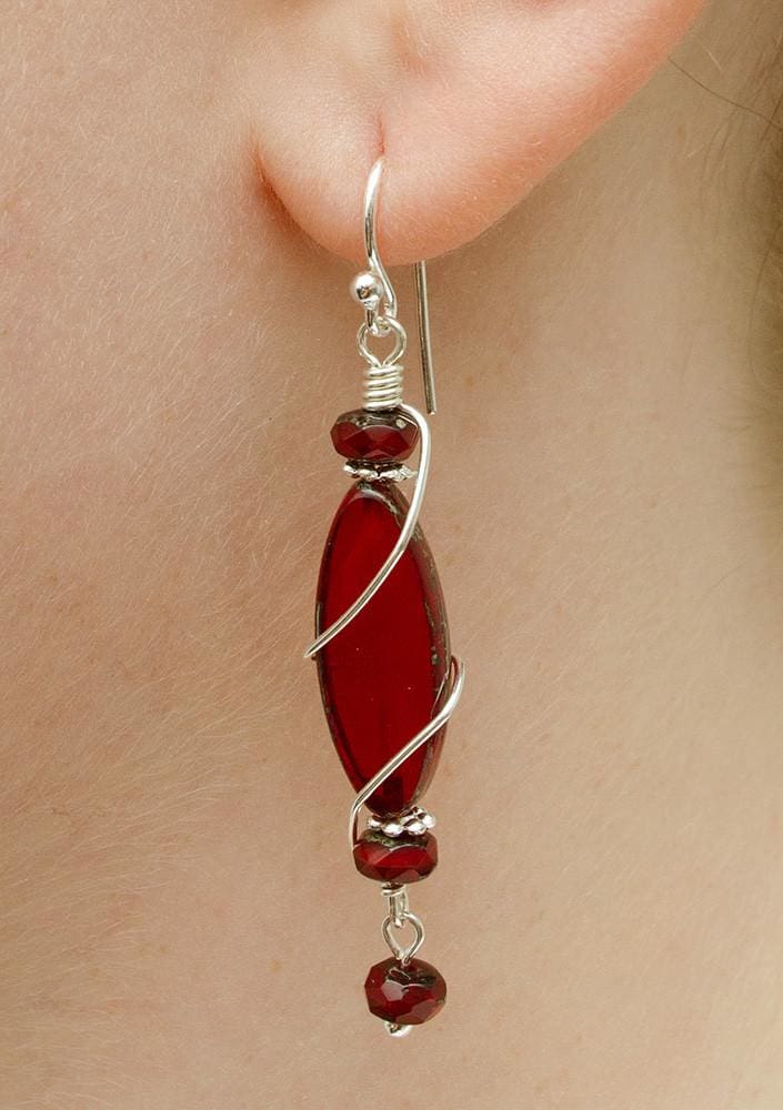 Rodanthe Earrings on model. Hypoallergenic. Red dangles encircled in silvery wire. 2" (51 mm) long.