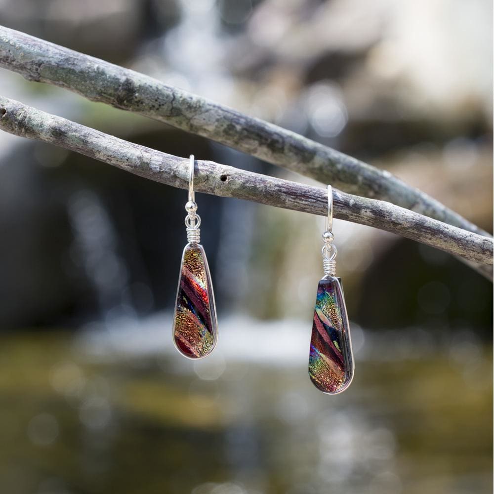 Sunburst Falls Earrings - Rainbow Red. Outdoor setting. Rainbow blend of colors pops in the light.